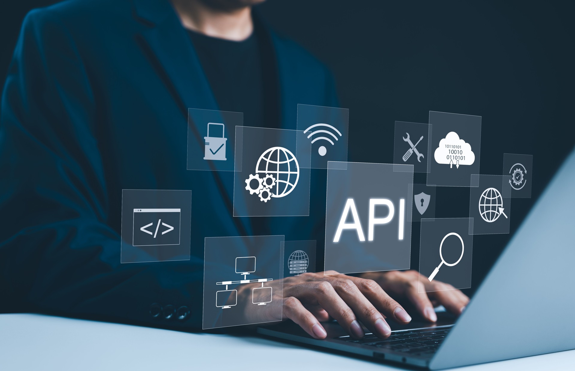 API Application Programming Interface Concept. A programmer types on a laptop, interacting with digital icons representing API development, security, and cloud computing. Application Software Tool,